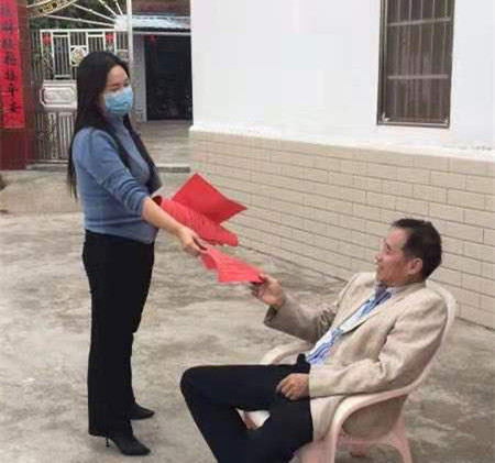 兴宁市新陂镇三新村最美网格员陈红兰向村民派发宣传资料.jpg