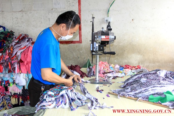 图为李师傅在裁剪布料.JPG
